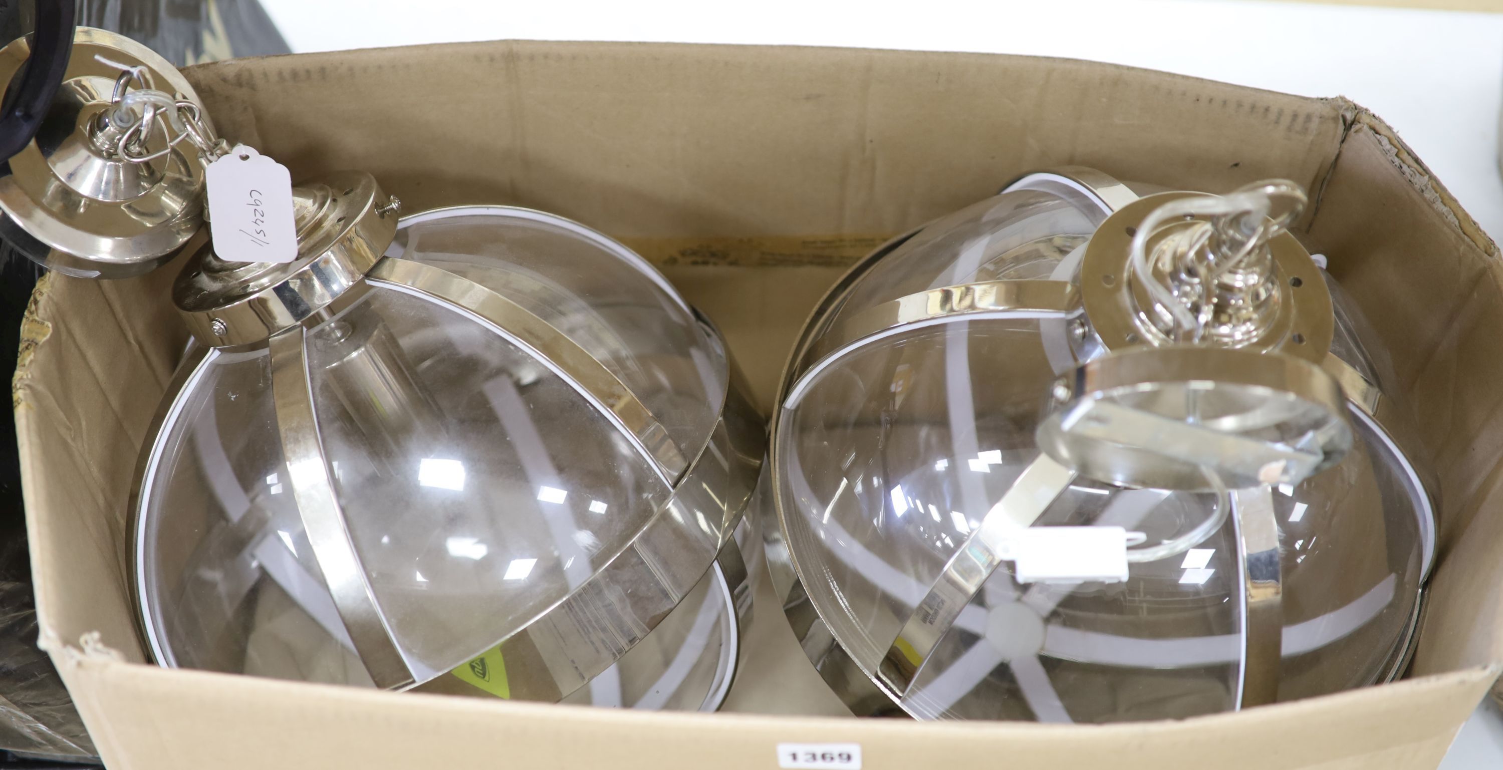 A large pair of globular framed clear glass ceiling lights